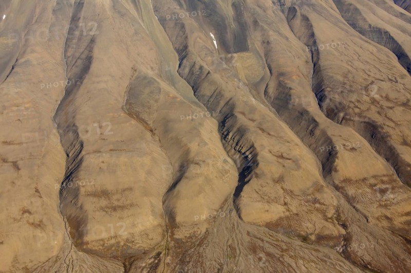 Aerial view of barren mountainside with deep gullies carved by water erosion at Spitsbergen