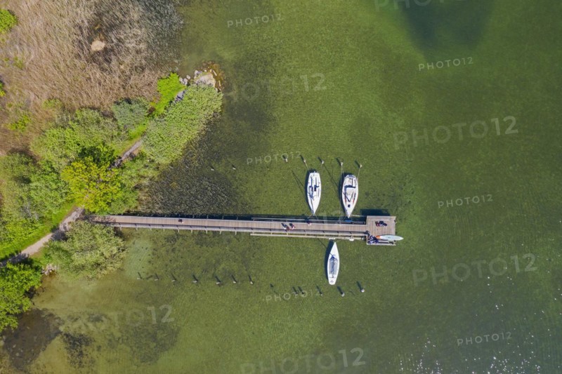 Aerial view over sailing boats moored at wooden jetty in lake Ratzeburger