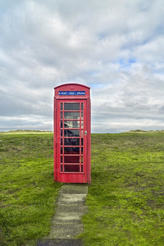 Red telephone box in meadow