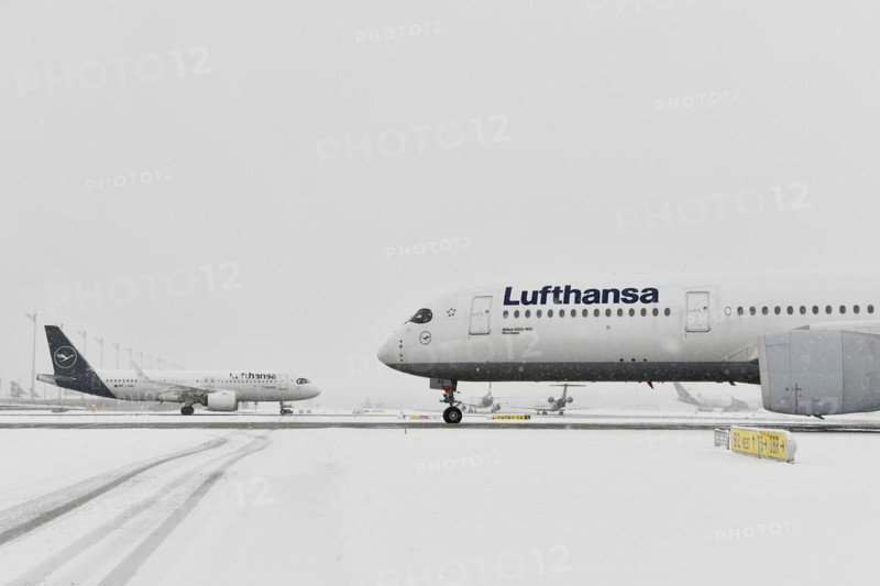 Aircraft taxiing on taxiway in winter snow flurry for de-icing and take-off clearance