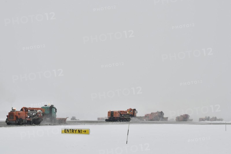 Road sweepers and snow ploughs clear snow on the taxiways and Runway North