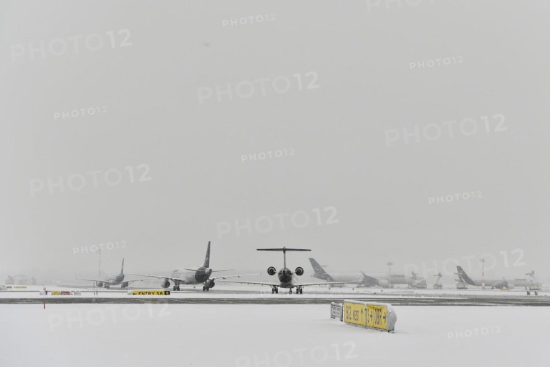 Aircraft in wait in winter snow flurry for de-icing and take-off clearance