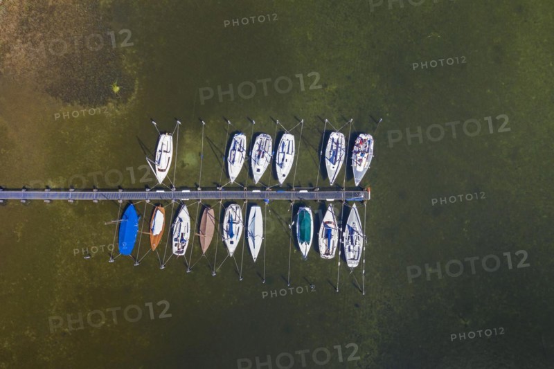 Aerial view over sailing boats moored at wooden jetty in lake Ratzeburger