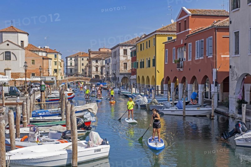 Tourists standup paddleboarding on canal Vena at Chioggia