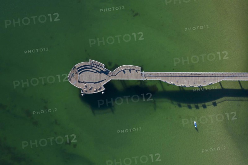 Aerial view over wooden fish-shaped pleasure pier at seaside resort Niendorf along the Baltic Sea