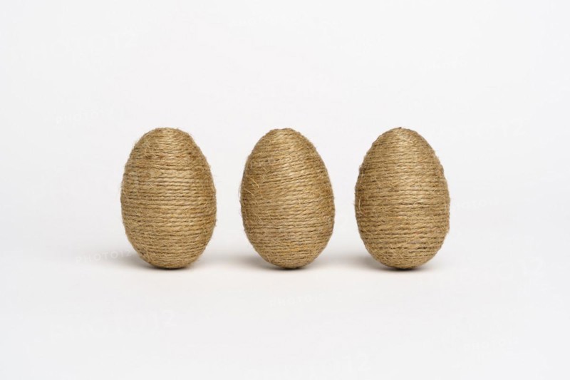 Hand wrapped easter eggs with jute twine, isolated white background. Studio