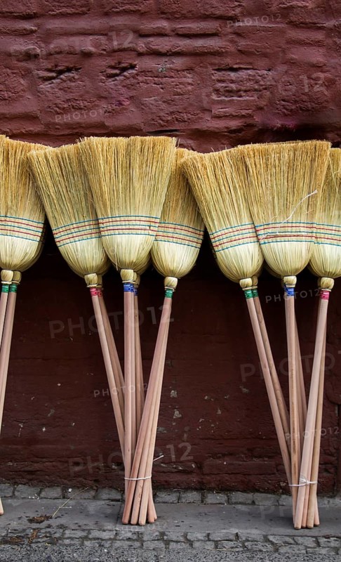 Set of yellow straw broom in a bazaar