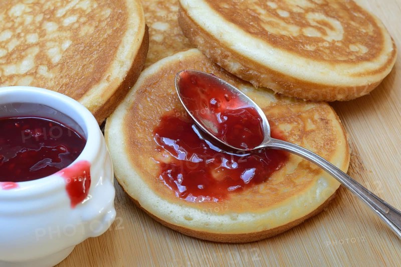 Pancake with raspberry jam and spoon