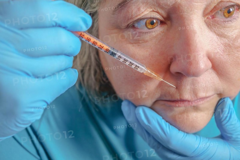 Older woman injected in lips Hyaluronic acid, Woman in beauty salon. plastic surgery clinic