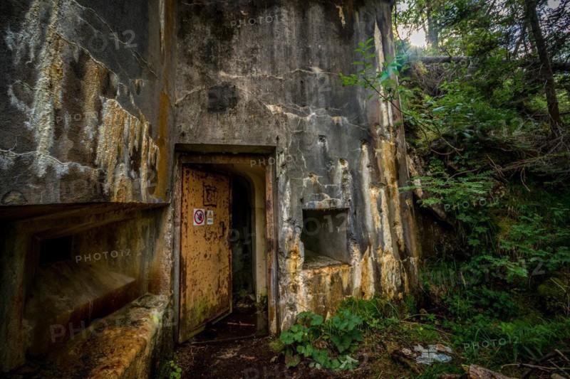 Abandoned, destoyed concrete bunker with embrasure in summer forest.Entrance to the bunker. Dolomites, Italy, Dolomites, Italy, Europe