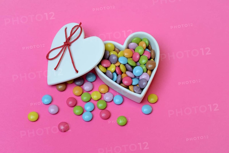 Chocolate lentils in heart-shaped container, Smartie