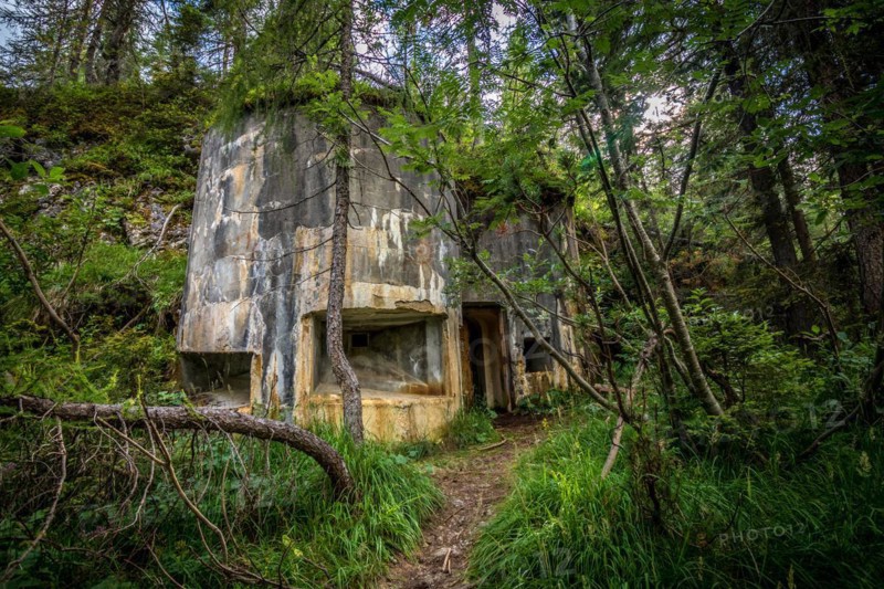 Abandoned, destoyed concrete bunker with embrasure in summer forest.Entrance to the bunker. Dolomites, Italy, Dolomites, Italy, Europe