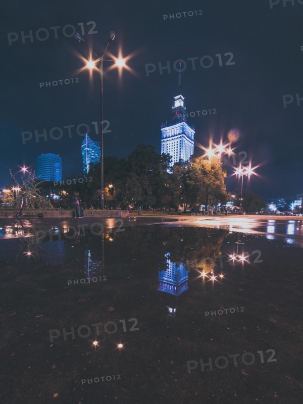 Night cityscape with reflections in the puddle