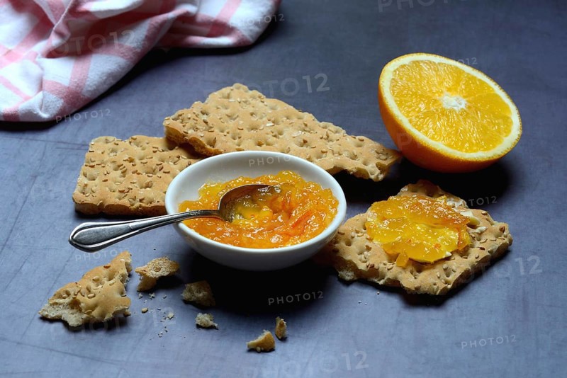 Orange marmalade in small bowls and on crispbread