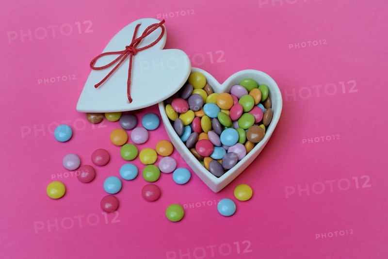 Chocolate lentils in heart-shaped container, Smartie