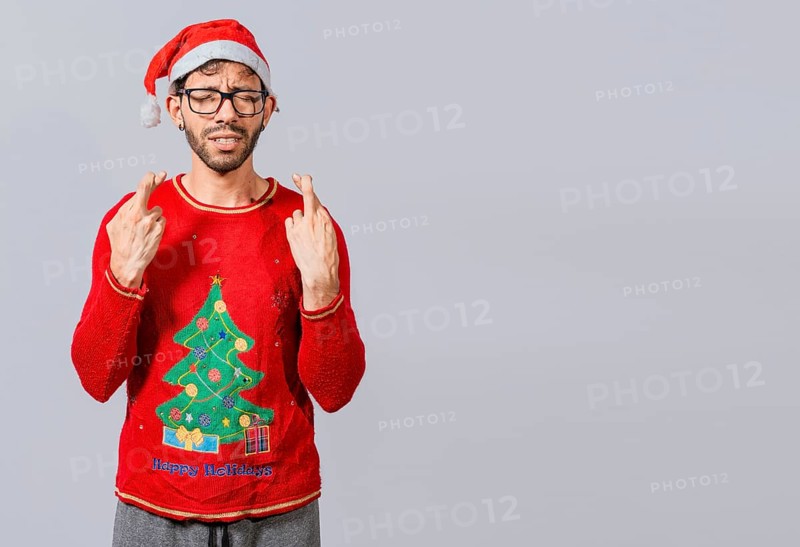 Guy with christmas hat making a wish on isolated background, Hopeful man in christmas clothes making a wish, Handsome man in christmas hat making a wish on white background
