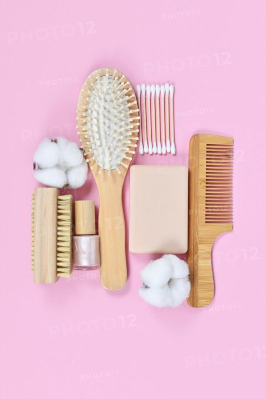 Eco friendly wooden beauty and hygiene products like comb and soap arranged on pink background