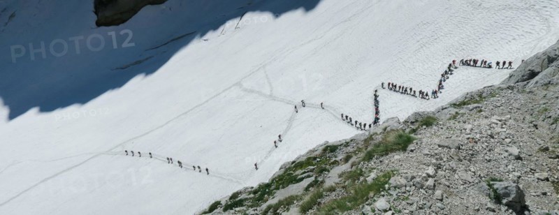 View from above on people walking on the zigzag glacier. Big queue, congestion. Zugspitze massif in the bavarian alps, Dolomites, Italy, Europe