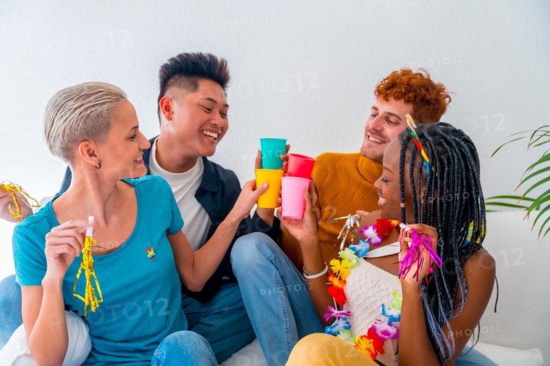 Lgtb couples of gay boys and girls lesbian in a portrait on a sofa at a house party, at a birthday party