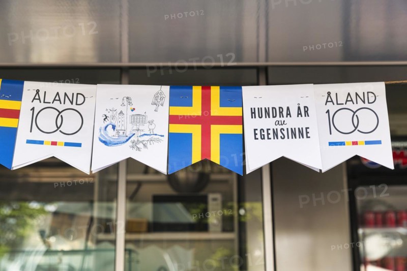 Various pennants for the anniversary, inscription 100 years of stubbornness, autonomy, flag Aland, Mariehamn, Aland Islands, Finland, Europe
