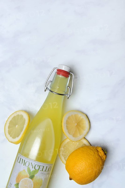 Limoncello, lemon liqueur in bottle and lemons