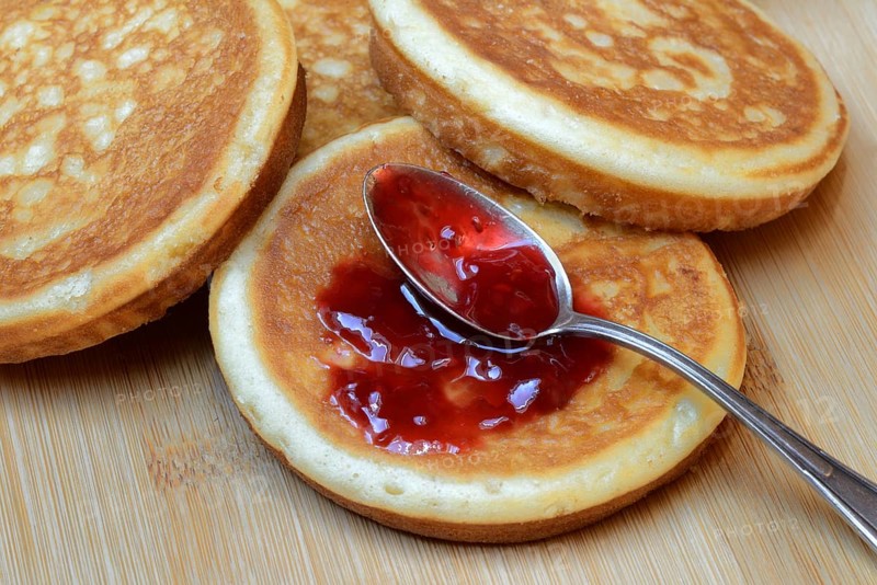 Pancake with raspberry jam and spoon