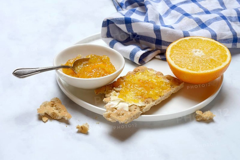 Orange marmalade in small bowls and on crispbread