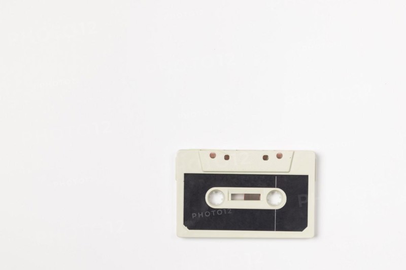 Old compact cassette on white background, copying room