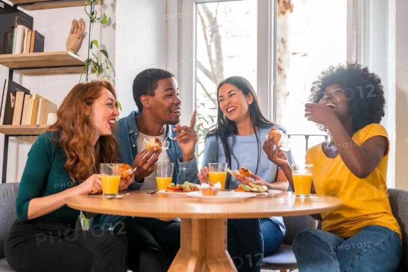 Friends at a breakfast with orange juice and muffins at home, together to celebrate good news
