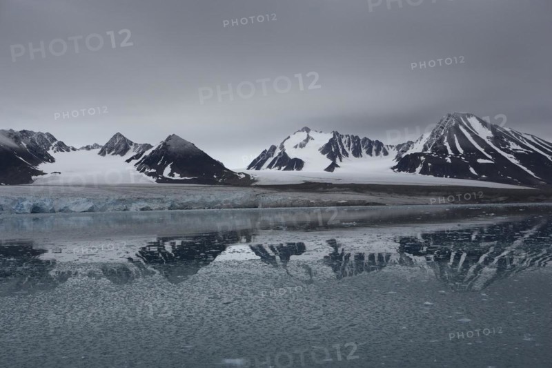 Lilliehook Glacier, Lilliehoeoekbreen, glaciated mountain peaks behind, with water reflection, in front ice chunks in the water, Lilliehook Fjord, Spitsbergen