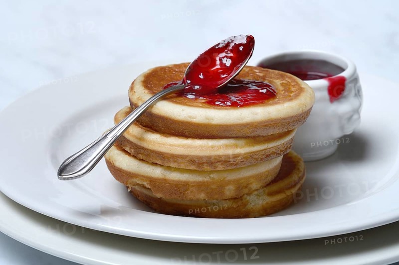 Pancake with raspberry jam and spoon