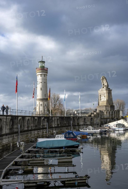 Lion pier with boats and Bavarian lion, in the back New Lindau lighthouse, Lindau harbour entrance, Lindau island, Lake Constance, Bavaria, Germany, Europe