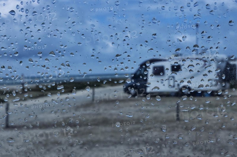View through a window with raindrops on a camper van on a camper van pitch by the sea, Portbail, Normandy, France, Europe