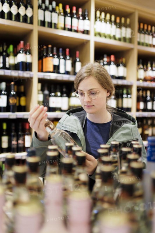 Young woman, student buys alcoholic drinks at the supermarket. Radevormwald, Germany, Europe