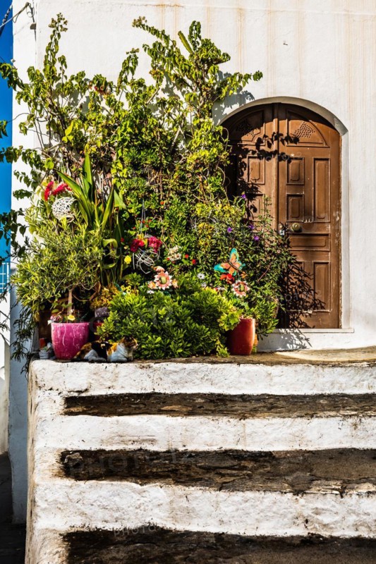 Old wooden doors with pebble mosaics on the floor, winding streets with white houses, Lindos, Rhodes, Greece, Europe