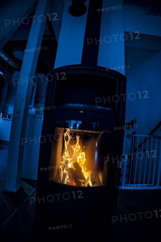 Symbolic photo: A fire burns in a stove in a flat. Berlin, 03.03.2023, Berlin, Germany, Europe