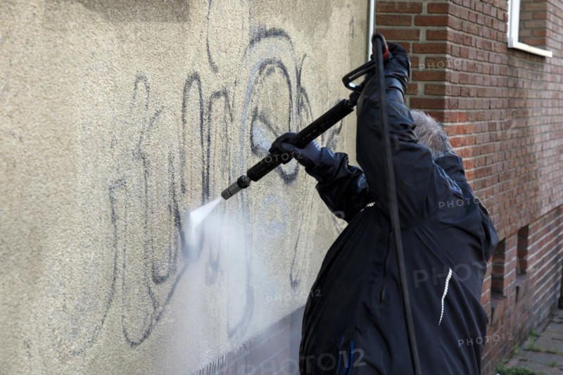 Removal of graffiti from house wall, high-pressure cleaner, residential area, Duesseldorf, North Rhine-Westphalia, Germany, Europe