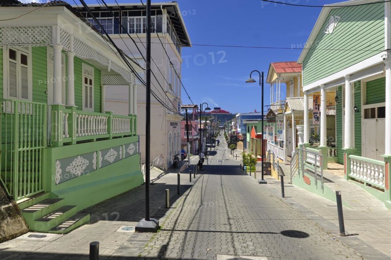 Colonial houses, Calle Duarte, chimney with exhaust fumes of the cruise ship Scarlet Lady, shipping company Virgin Voyages, in the port of Puerto Plata, Dominican Republic, Caribbean, Central America