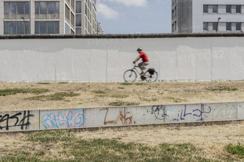 A cyclist at the Berlin Wall stands out at the East Side Gallery in Berlin, 26.06.2022., Berlin, Germany, Europe
