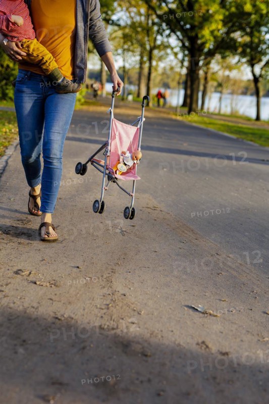 Mother carrying a pram and a child. Bonn, Germany, Europe