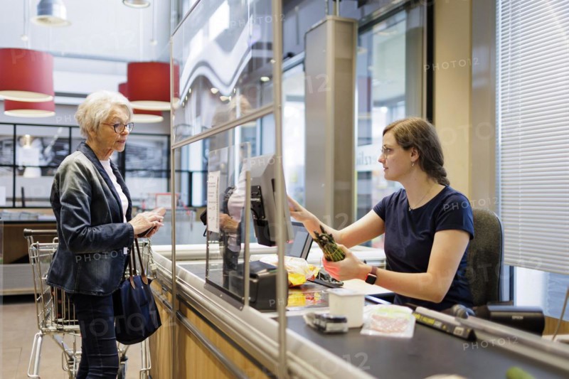 Elderly woman shopping in the supermarket. Radevormwald, Germany, Europe