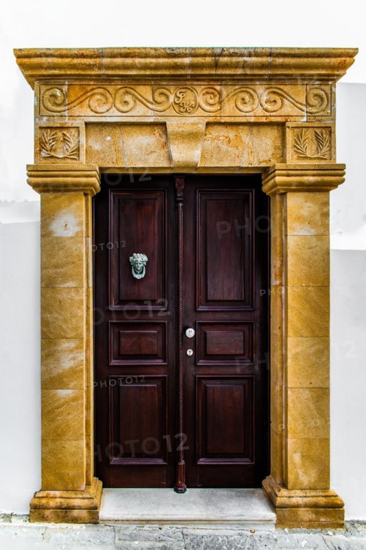 Old wooden doors with pebble mosaics on the floor, winding streets with white houses, Lindos, Rhodes, Greece, Europe