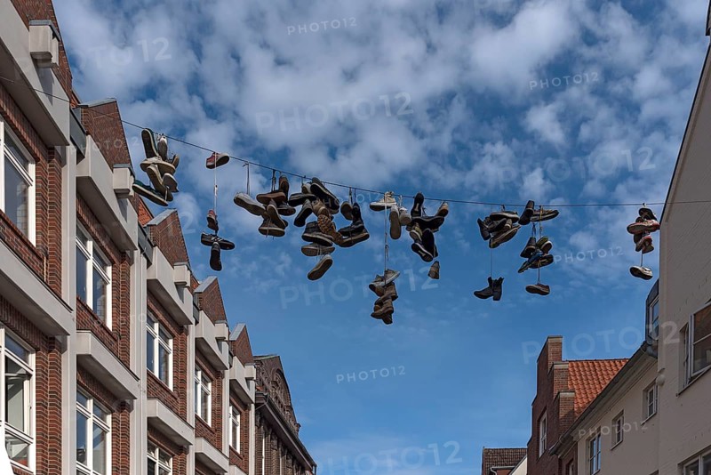 New street art Shoefiti, trainers hanging on a leash in the pedestrian zone, Lueneburg, Lower Saxony, Germany, Europe