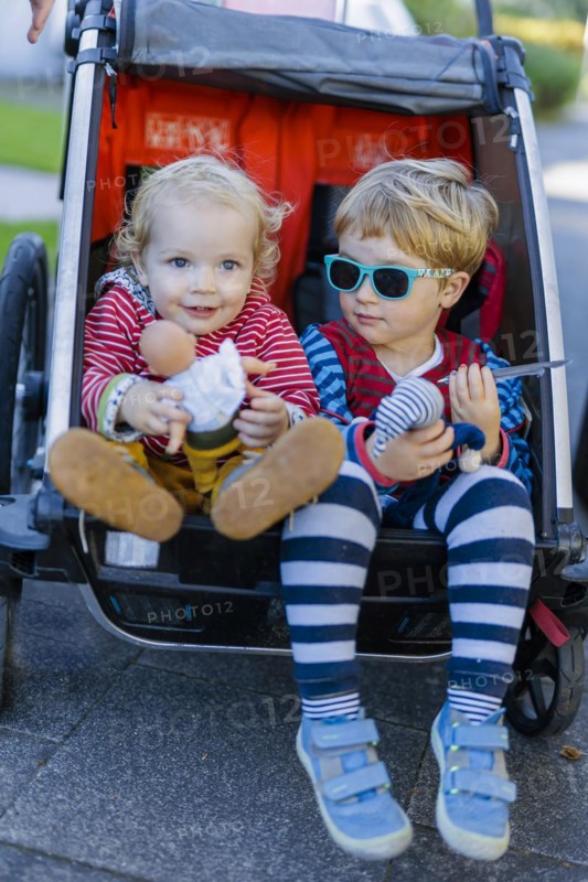 Siblings in a bicycle trailer. Bonn, Germany, Europe