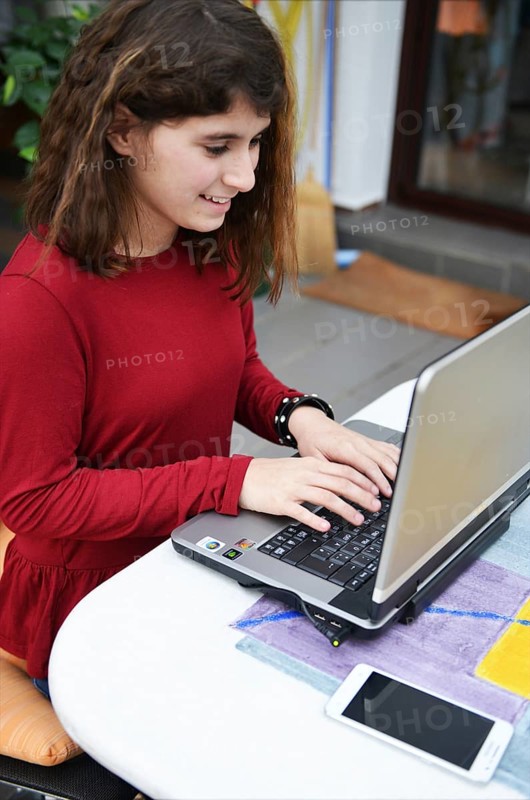 An 11-year-old girl stands as a model. Laptop, Germany, Europe