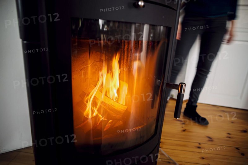 Symbolic photo: A fire burns in a stove in a flat. Berlin, 03.03.2023, Berlin, Germany, Europe