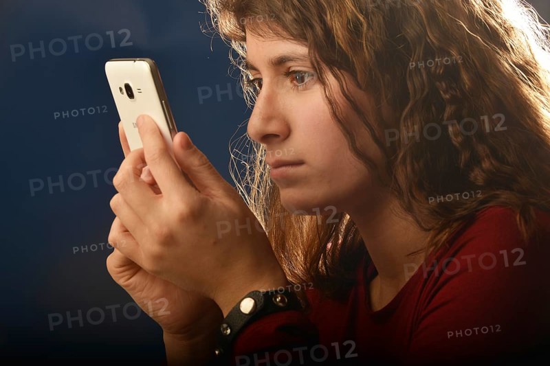 An 11-year-old girl stands as a model. With mobile phone, Germany, Europe