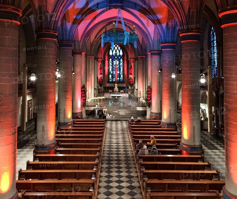 View from elevated position on festively lit interior central nave of Essen Cathedral Muenster former collegiate church cathedral church bishop's seat Ruhrbistum diocese Essen, Advent wreath hanging from ceiling above, Essen, North Rhine-Westphalia, Germany, Europe