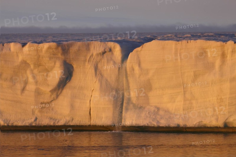 Brasvellbreen coastal glacier, glacier front with waterfall of melting ice, evening light at sunset, Nordaustlandet, Svalbard