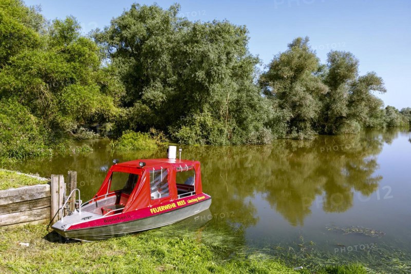Flooding after heavy rain in North Rhine-Westphalia in the nature reserve at the Grietherorter and Bienener Altrhein, road flooded, boat of the fire brigade Rees, Rees, North Rhine-Westphalia, Germany, Europe